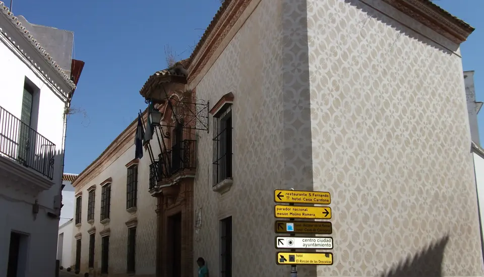 Palacio de los Domínguez (Carmona) 1 Edificio histórico en calle con señales direccionales