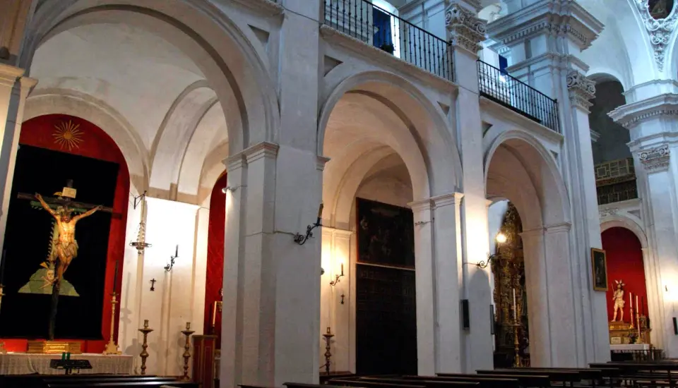 Templo del Salvador (Carmona) 1 Interior de iglesia con crucifijo y arcos grandes.