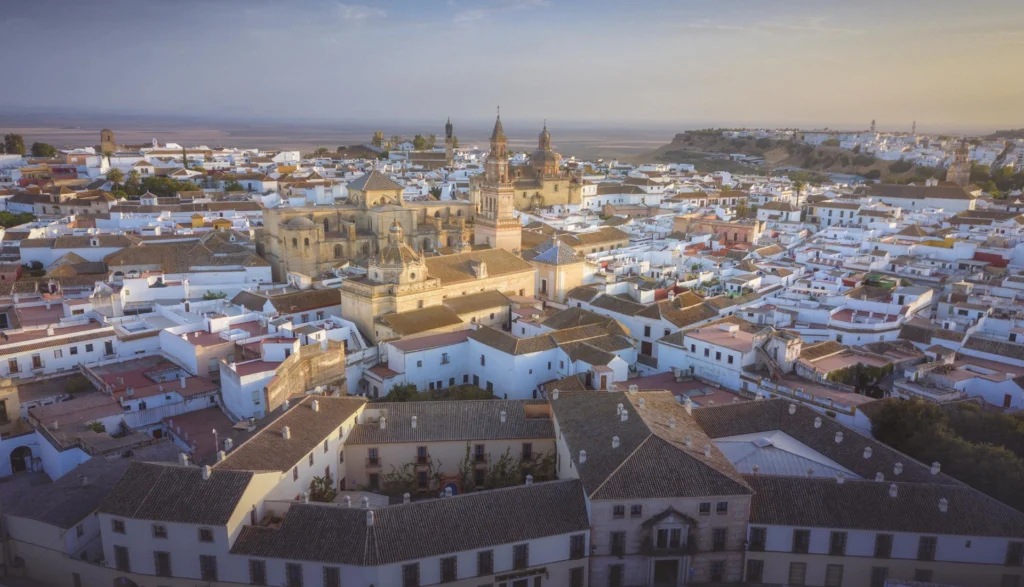 Vista aérea de pueblo con iglesia al atardecer.